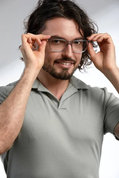 Handsome, smiling, young man with dark long hair and stylish glasses isolated on gray background, in stylish clothes, positive and success in career and business. — Stock Photo, Image