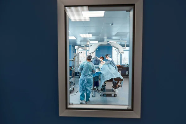 Schnappschuss am Eingang des Operationssaals, durch die Tür, Operationseinheit, Operation, die die eigentliche Operation ausführt. — Stockfoto