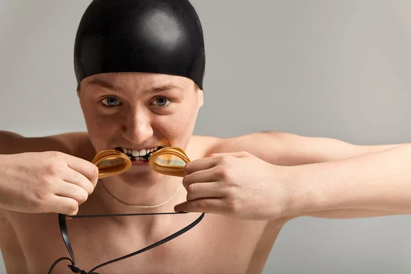 Nadador joven en excelente forma física, sobre un fondo gris con espacio para copiar, llamar para deportes, banner publicitario — Foto de Stock