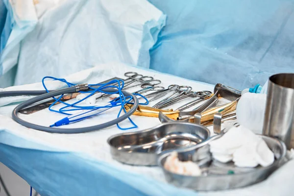 Conjunto de instrumentos quirúrgicos dispuestos sobre un paño azul estéril — Foto de Stock
