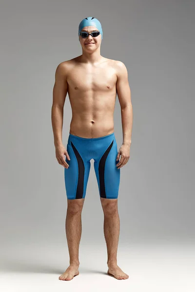 Retrato de um nadador com boné e máscara, retrato completo, jovem atleta nadador com boné e máscara para nadar, cópias do espaço, fundo cinzento — Fotografia de Stock