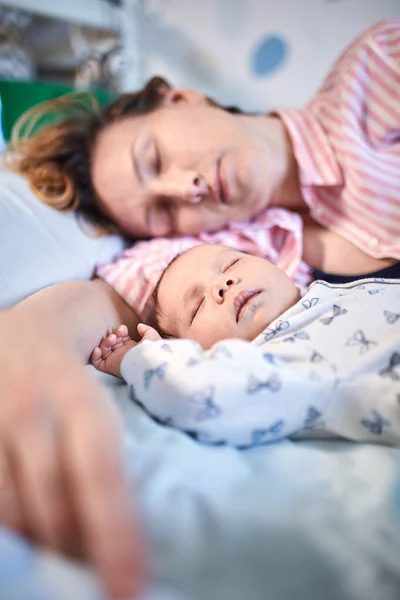 新生婴儿和母亲睡在床上, 一起休息的肖像 — 图库照片