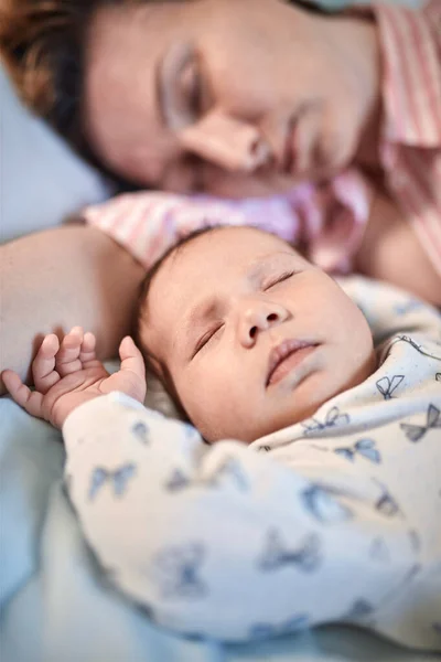 Porträt von Neugeborenem und Mutter, die zusammen auf dem Bett schlafen und ausruhen — Stockfoto