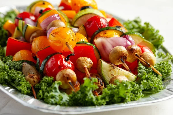 Spiedini vegetariani con erbe secche su spiedini di legno di funghi di cipolla di pomodoro di zucchine su un piatto — Foto Stock