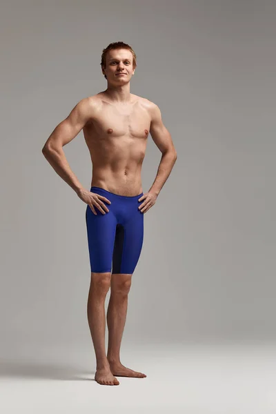 Jovem nadador em excelente forma física, em um fundo cinza com espaço de cópia, chamada para esportes, banner publicidade — Fotografia de Stock