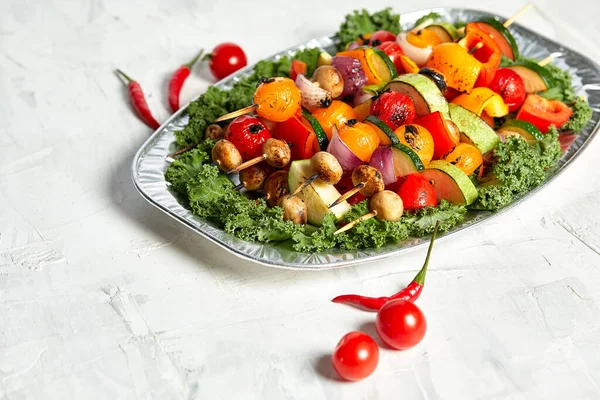 Vegetarische Spieße mit trockenen Kräutern auf hölzernen Spießen aus Zucchini-Tomaten-Zwiebelpilzen auf einem Teller — Stockfoto