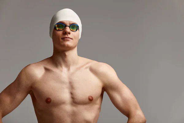 Porträt einer Schwimmerin mit Mütze und Maske, halblanges Porträt, junge Schwimmerin mit Mütze und Maske zum Schwimmen, Kopien des Weltraums, grauer Hintergrund — Stockfoto