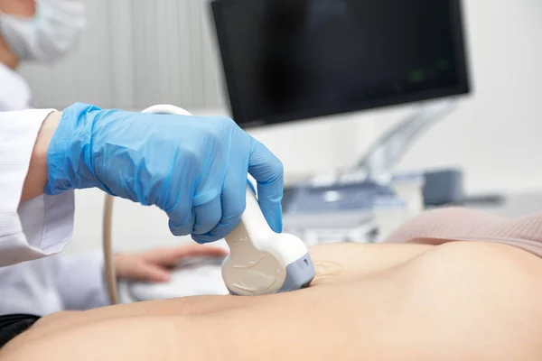 La doctora le hace una ecografía abdominal a la paciente. Escáner de ultrasonido en las manos de un médico. —  Fotos de Stock