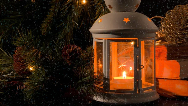 燃えるろうそくのある白い提灯 クリスマスツリーの枝や背景にライト 雪が降る 夜の暗い画像 クリスマスの神秘的な気分 — ストック写真