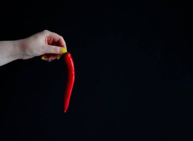 Siyah arka planda taze kırmızı biber. El ele tutuşun kırmızı biber.