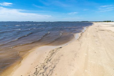 Lagoa dos Barros Gölü, Osorio, Rio Grande do Sul, Brezilya 'da mavi gökyüzü ile kum ve göl