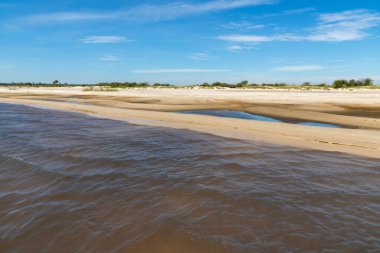 Lagoa dos Barros Gölü, Osorio, Rio Grande do Sul, Brezilya 'da mavi gökyüzü ile kum ve göl