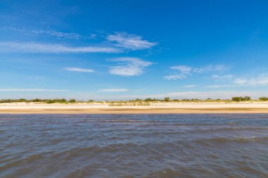 Lagoa dos Barros Gölü, Osorio, Rio Grande do Sul, Brezilya 'da mavi gökyüzü ile kum ve göl
