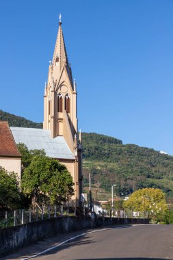 Arka planda orman ve dağ olan köydeki kilise kulesi, Santa Maria do Herval, Rio Grande do Sul, Brezilya