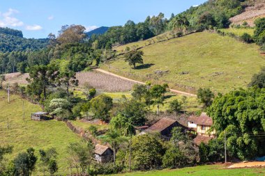 Pnhal Alto, Nova Petropolis, Rio Grande do Sul, Brezilya 'da bir vadide küçük bir ev ve odun kulübesi olan çiftlik arazisi.