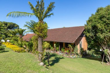 Çimenli, çiçekli, ağaçlı küçük bir ev ve bahçe ve bir köpek, Pnhal Alto, Nova Petropolis, Rio Grande do Sul, Brezilya