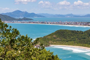 Quatro Ilhas plajlarında binalar, dağlar, orman ve arka planda Mariscal plajı, Bombinhas, Santa Catarina, Brezilya