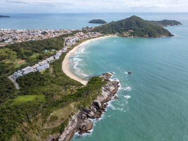 Bombinhas sahillerinin havadan görünüşü binalar, kum, kayalar ve orman, Bombinhas, Santa Catarina, Brezilya