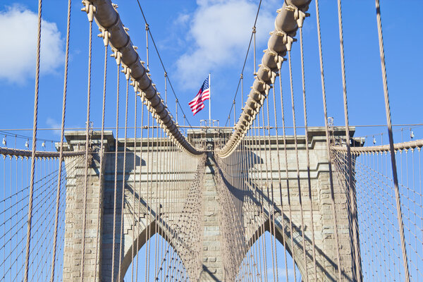 American flag located over brooklyn bridge.