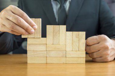 İşadamı ahşap bloklar ile bir bina yapmak