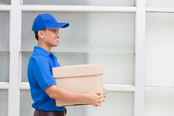 Entrega hombre sosteniendo una caja de paquete —  Fotos de Stock