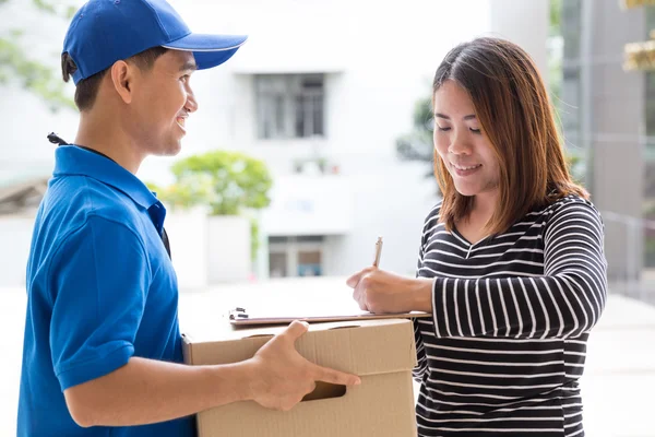 Mujer asiática firma recibo del paquete entregado —  Fotos de Stock