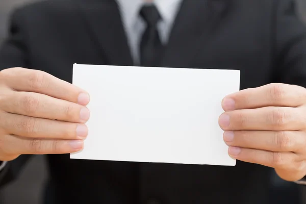 Hand of businessman showing white paper — Stock Photo, Image