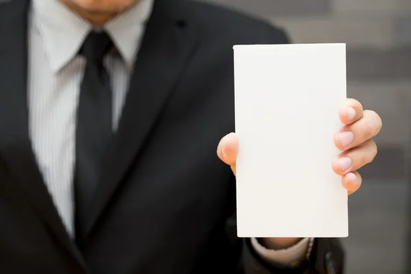 Рука бизнесмена показывает белую бумагу — стоковое фото