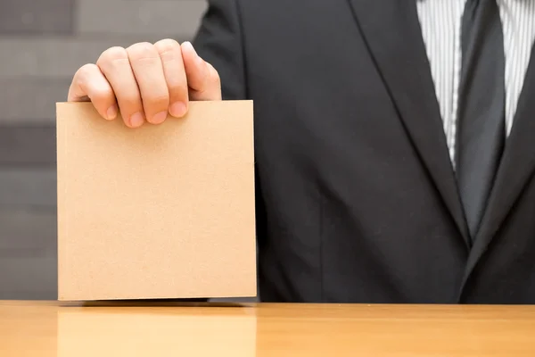 Mano de hombre de negocios mostrando libro marrón — Foto de Stock