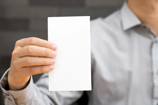 Mão de homem de negócios mostrando papel branco — Fotografia de Stock