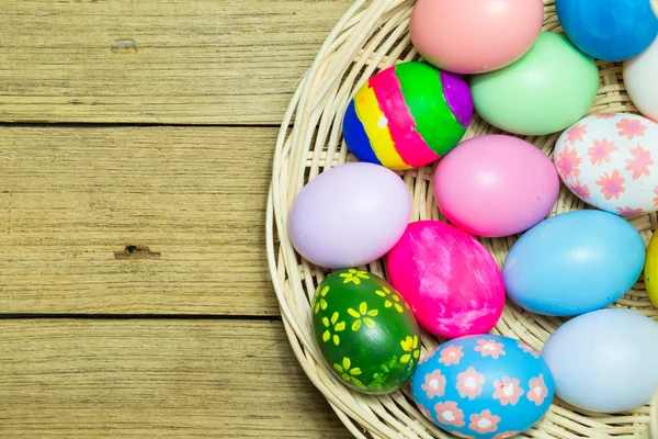 Uova di Pasqua nel cestino su fondo legno — Foto Stock