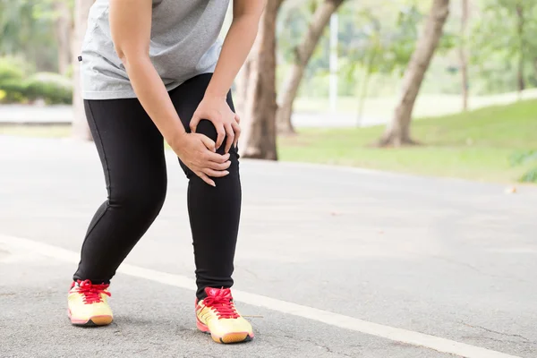 运动损伤。在慢跑的时候膝盖疼痛的女人 — 图库照片