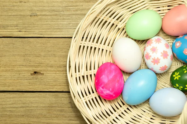 Uova di Pasqua nel cestino su fondo legno — Foto Stock