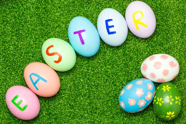 Top view of easter eggs on green grass background — Stock Photo, Image