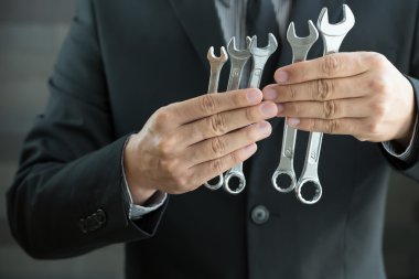 İngiliz anahtarını elinde tutan işadamı