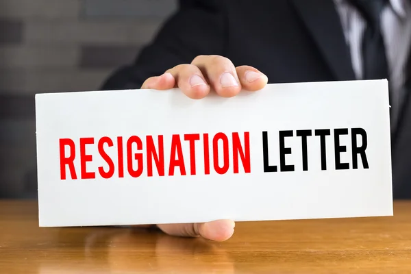 Επιστολή παραίτησης, μήνυμα σε λευκή κάρτα και κρατήστε από businessma — Φωτογραφία Αρχείου