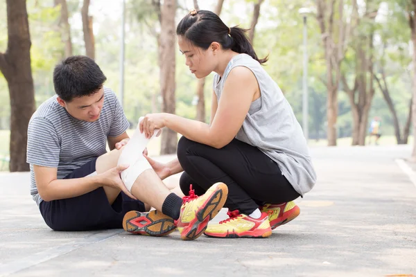 Sports injury. Man with twisted sprained knee and getting help f