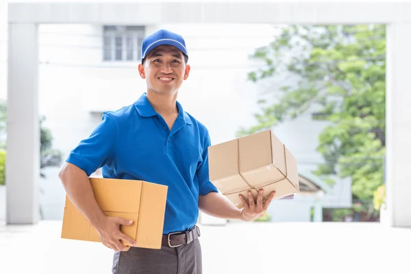 Entrega homem segurando uma caixa de pacote — Fotografia de Stock