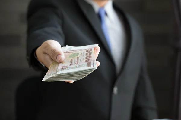 Businessman holding money thai baht — Stock Photo, Image