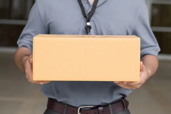 Курьер держит коробку с посылкой. — стоковое фото
