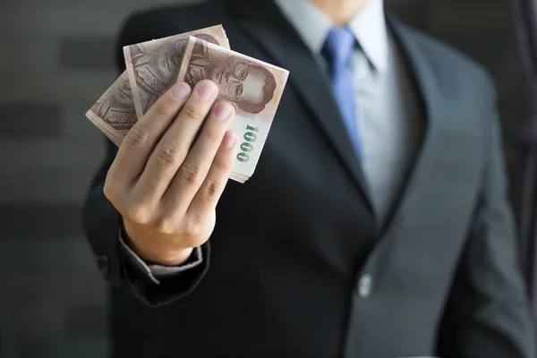 Businessman holding money thai baht — Stock Photo, Image