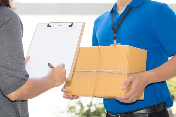 Woman hand signing receipt of delivered package — Stock Photo, Image