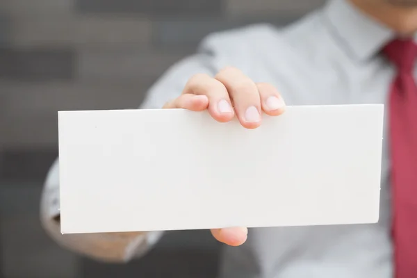 Рука бизнесмена показывает белую бумагу — стоковое фото