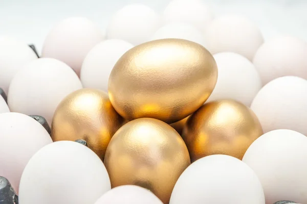 Golden eggs among the white eggs — Stock Photo, Image