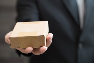 İşadamı kahverengi kutusu veren takım elbiseli