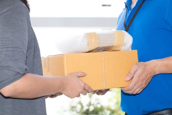 Mulher mão aceitar uma entrega de caixas de entregador — Fotografia de Stock
