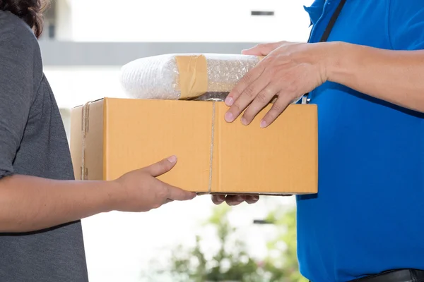 Mujer mano aceptar una entrega de cajas de repartidor — Foto de Stock