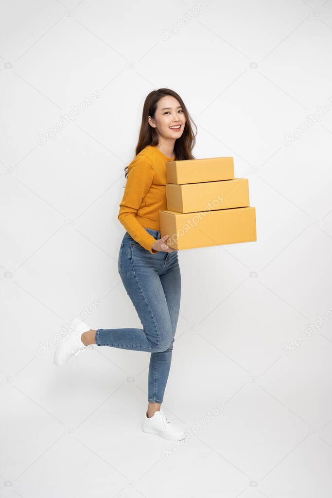 Happy Asian woman smiling and holding package parcel box isolated on white background, Delivery courier and shipping service concept, Full Length people composition