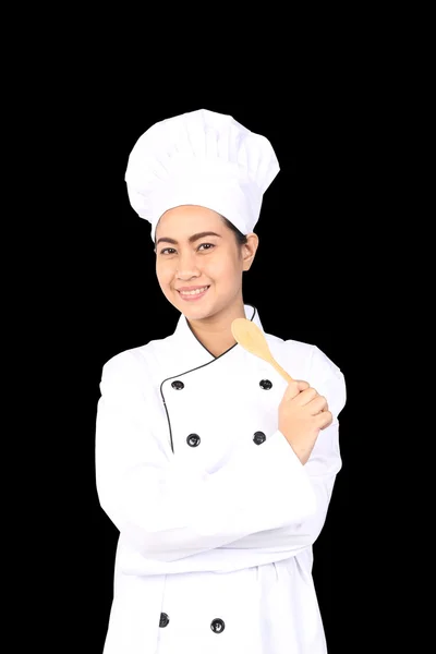 Retrato de mujer joven chef con cuchara de madera aislada en negro b — Foto de Stock