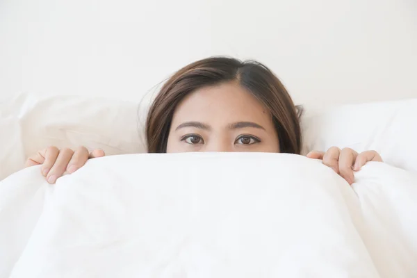 Asiatin liegt unter Decke im Bett — Stockfoto